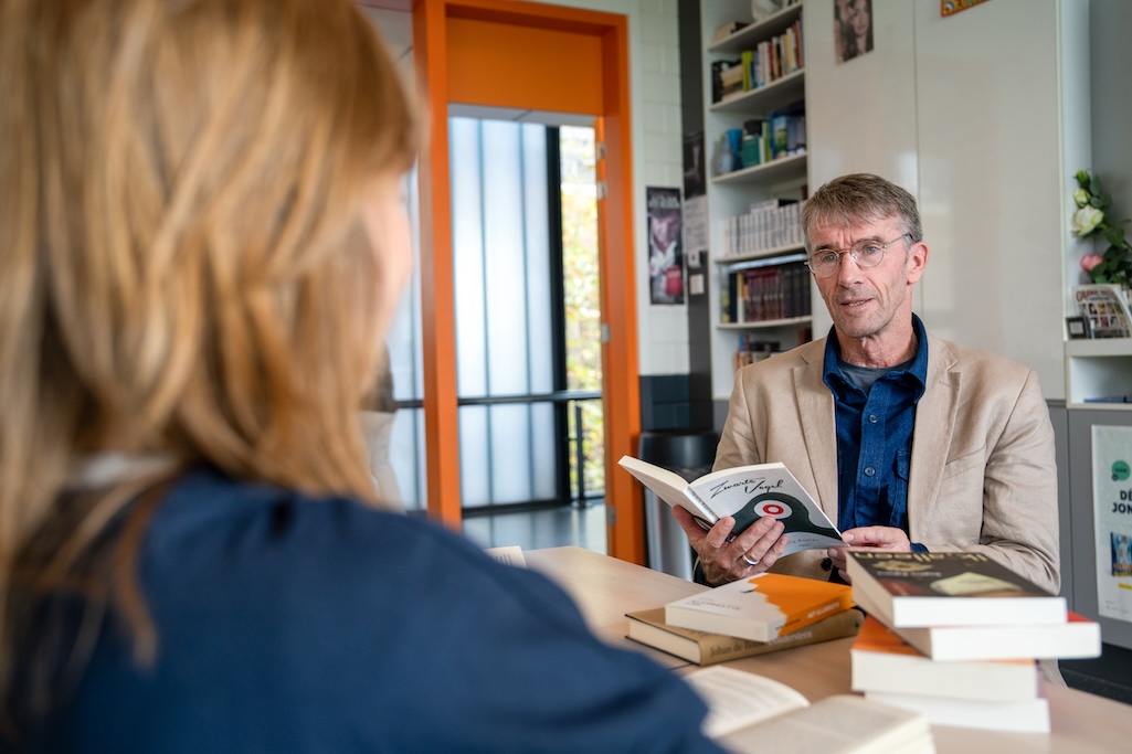 Leraar leest voor uit een boek in de klas